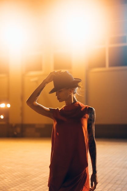 Free Photo the young, attractive girl in a hat poses to the camera at night