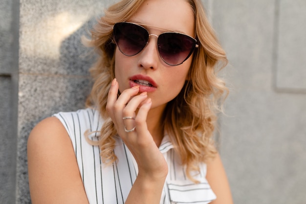 Free Photo young attractive stylish blonde woman walking in city street in summer fashion style dress wearing sunglasses, sexy look