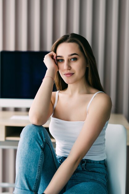 Young attractive woman sitting on the chair in modern loft apartment