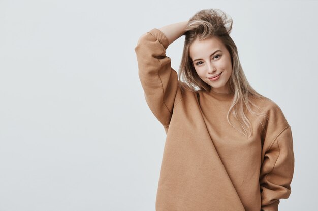 Young attractive woman wearing stylish long-sleeved sweatshirt and posing