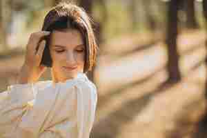 Free photo young attractive woman in white dress in forest