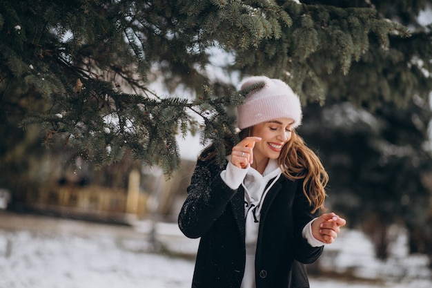 Young attractive woman in a winter park in a cute hat