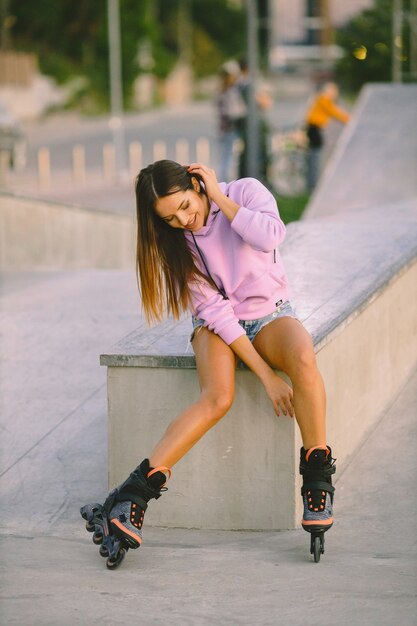 Young attractive woman with roller skates in park