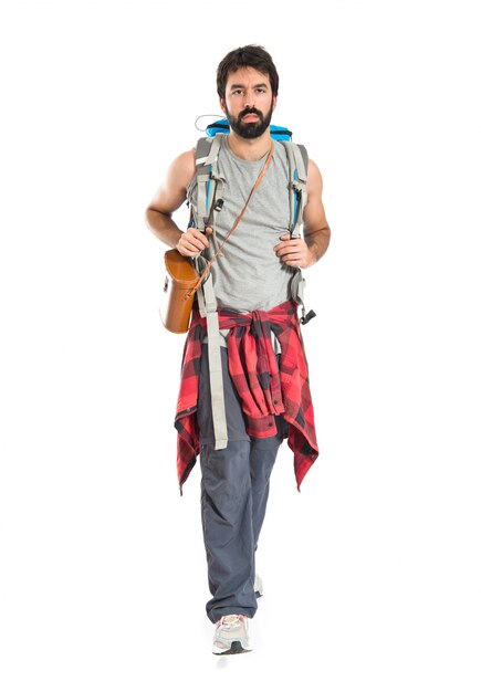 Young backpacker walking over white background