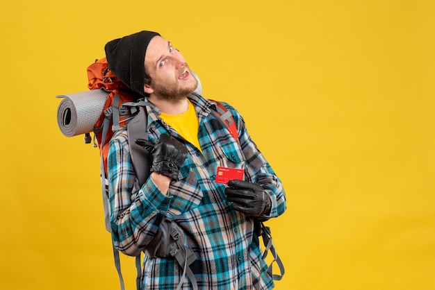 Free photo young backpacker with black hat holding discount card