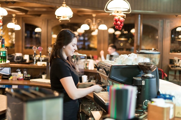 Free photo young barista making coffee