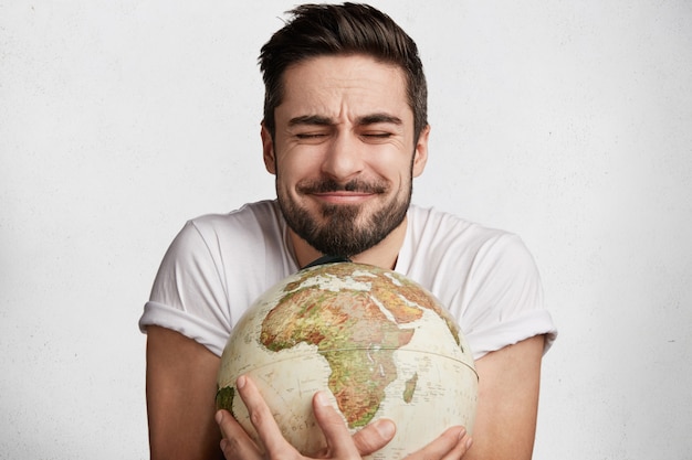 Free photo young bearded man with globe