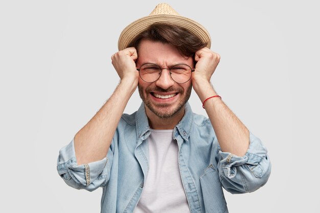 Young bearded man with round glasses and denim shirt