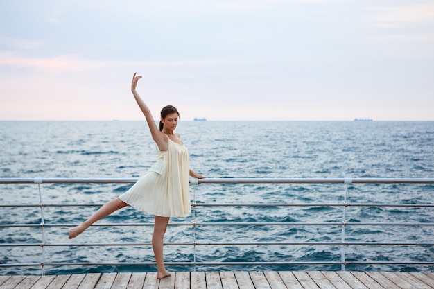 Young beautiful ballerina dancing and posing outside