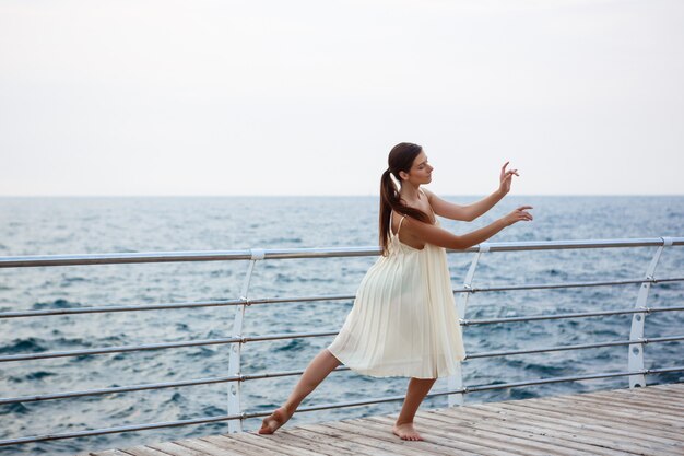 Young beautiful ballerina dancing and posing outside