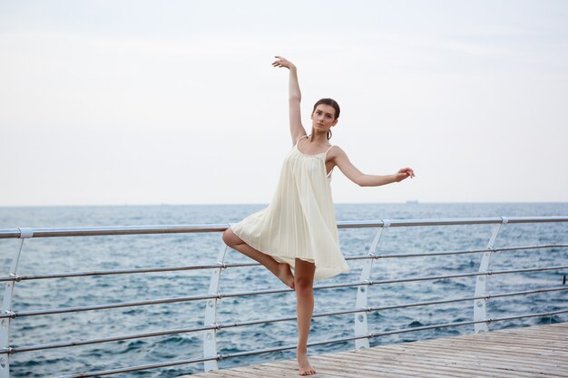 Young beautiful ballerina dancing and posing outside