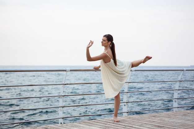 Young beautiful ballerina dancing and posing outside