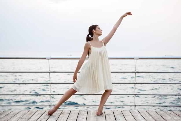 Young beautiful ballerina dancing and posing outside