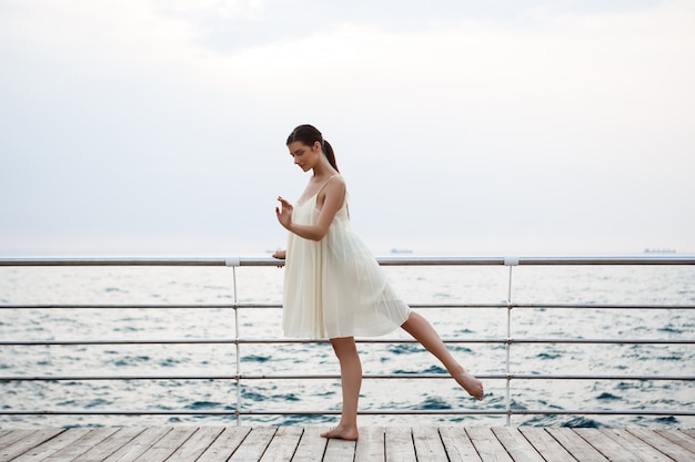 Young beautiful ballerina dancing and posing outside