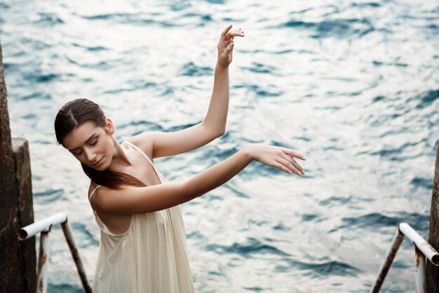 Young beautiful ballerina dancing and posing outside