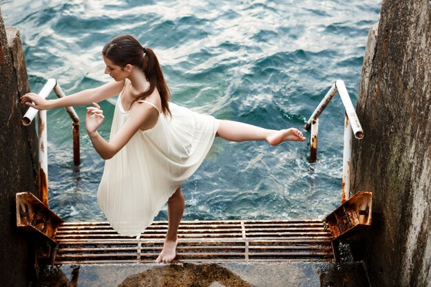 Young beautiful ballerina dancing and posing outside