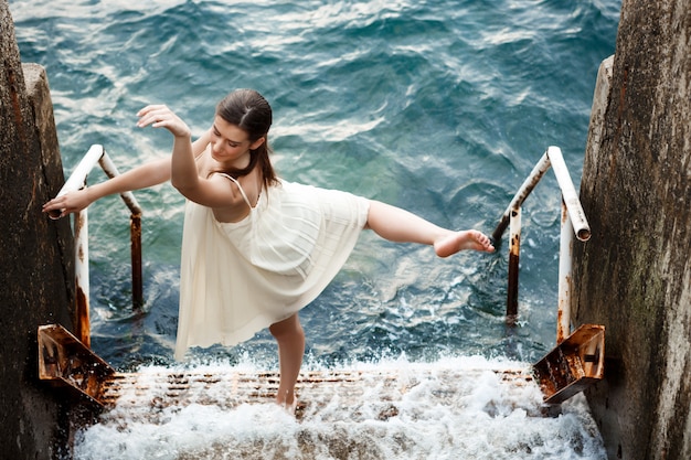 Young beautiful ballerina dancing and posing outside