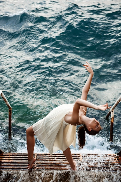 Young beautiful ballerina dancing and posing outside