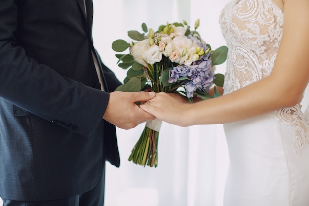 A young and beautiful bride is standing with her husband