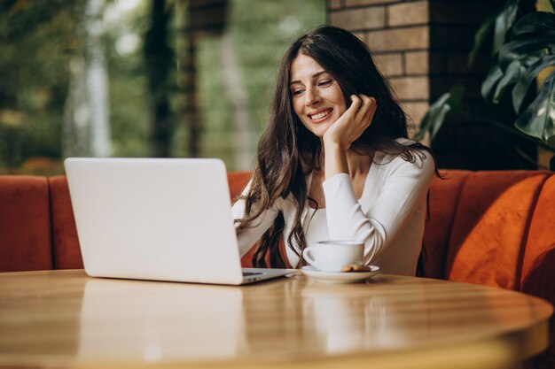 Young beautiful business woman working on computer in a cafe