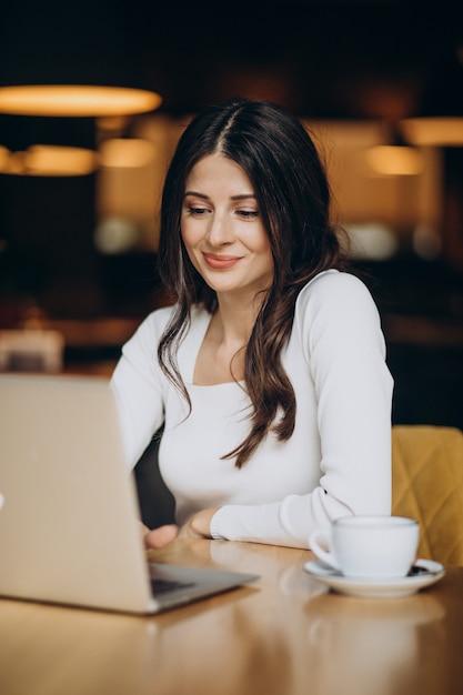 Young beautiful business woman working on computer in a cafe