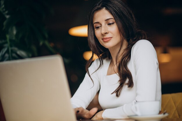 Young beautiful business woman working on computer in a cafe