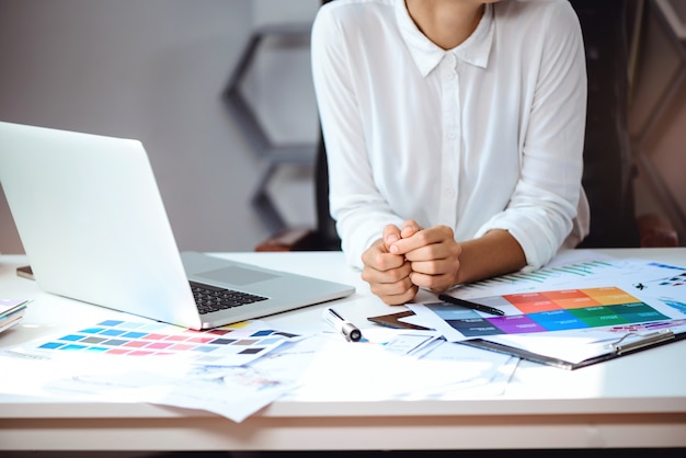 Young beautiful businesswoman sitting at workplace in office. Close up.