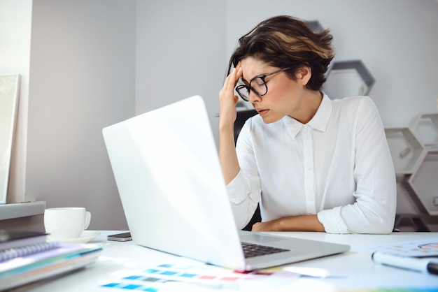 Young beautiful businesswoman working with laptop at workplace in office.