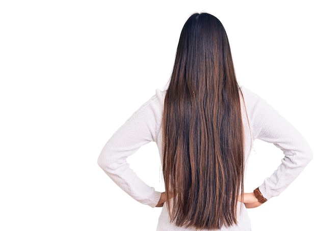 Young beautiful chinese woman wearing casual sweater standing backwards looking away with arms on body