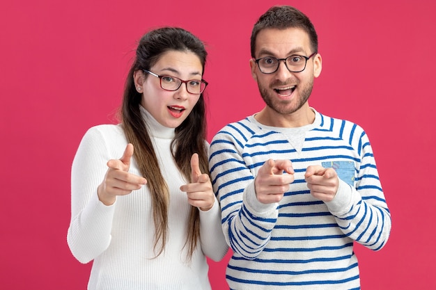 young beautiful couple happy man and woman in casual clothes wearing glasses happy and cheerful pointing with index fingers