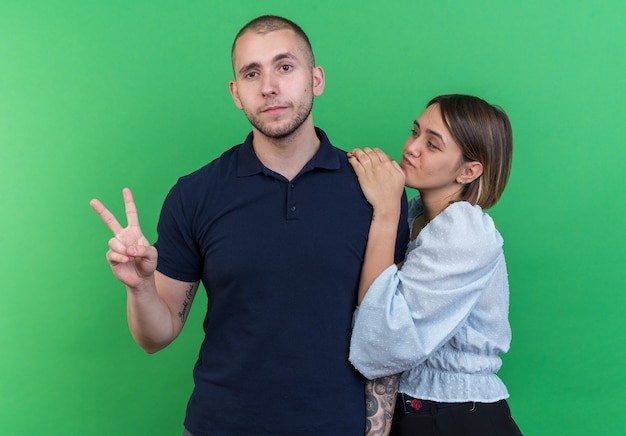 Young beautiful couple man and woman happy and positive showing v-sign smiling cheerfully standing