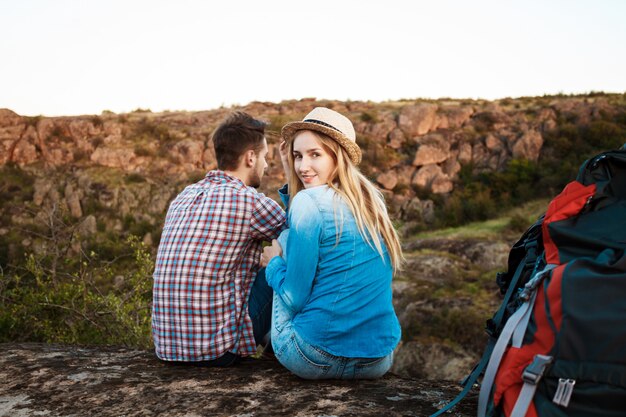 Young beautiful couple of travelers enjoying view of canyon, smiling