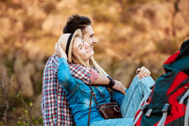 Young beautiful couple of travelers enjoying view of canyon, smiling