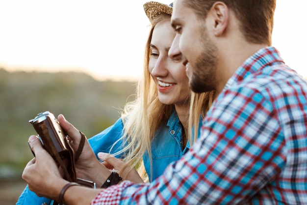 Free Photo young beautiful couple of travelers smiling, holding old camera