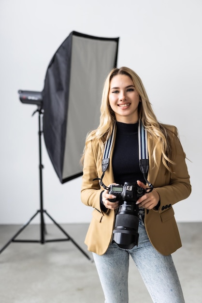 Young beautiful female posing for a photo shoot in a studio a photographer is shooting with a digital camera