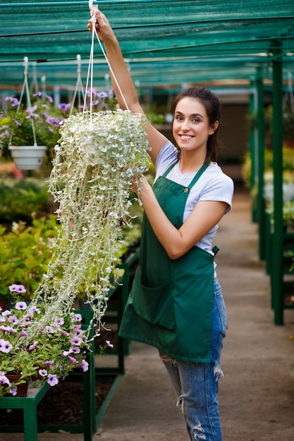 Young beautiful florist taking care of flowers.