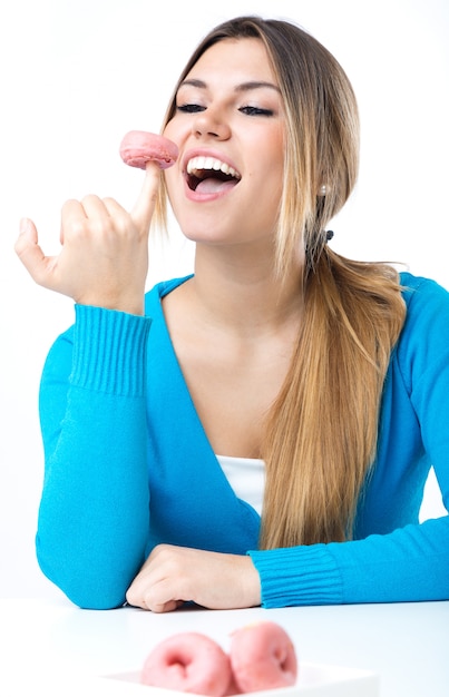 Young beautiful girl eating donut. Isolated on white.