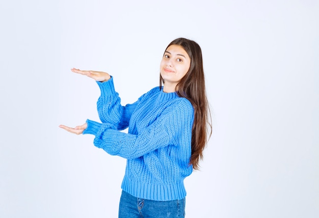 Young beautiful girl gesturing with hands showing big and large size sign.