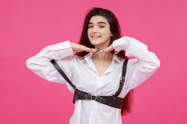 Young beautiful girl holding her hands to her chin and smiling for the camera