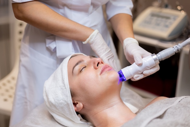 A young beautiful girl lies on the beautician's table and receives procedures