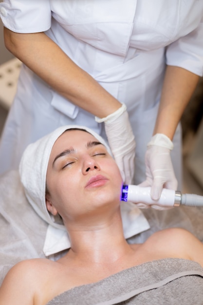 A young beautiful girl lies on the beautician's table and receives procedures