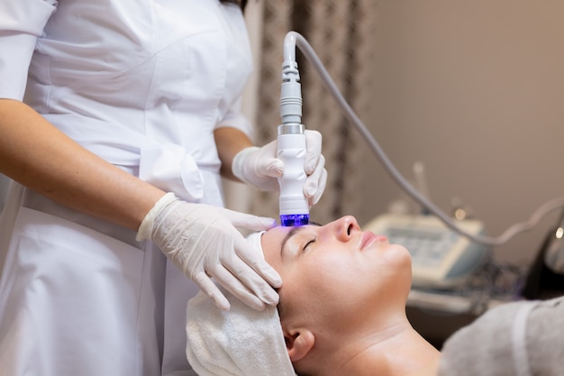 A young beautiful girl lies on the beautician's table and receives procedures