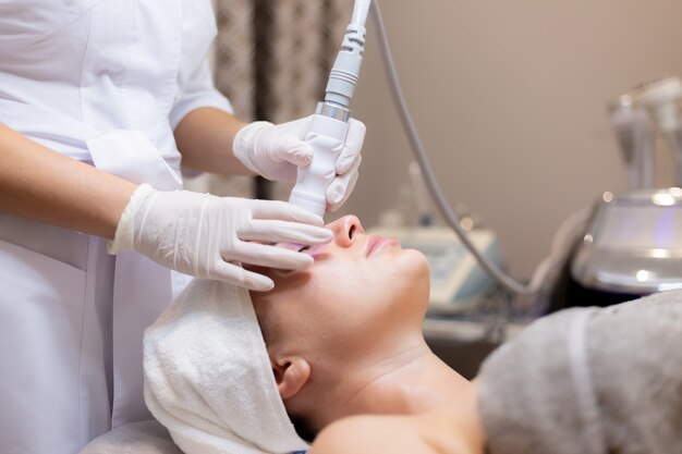 A young beautiful girl lies on the beautician's table and receives procedures