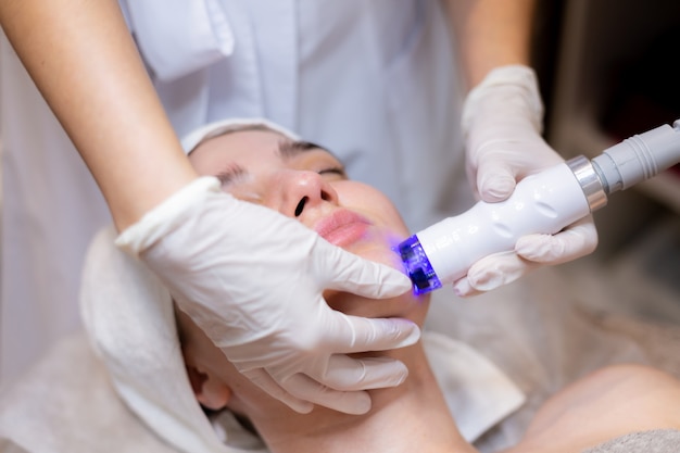 A young beautiful girl lies on the beautician's table and receives procedures