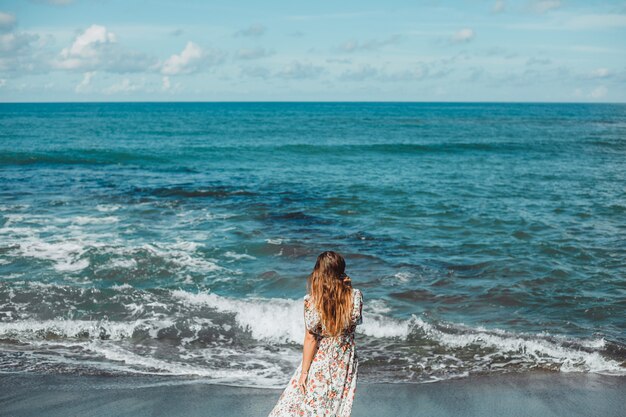 young beautiful girl posing on the beach, ocean, waves, bright sun and tanned skin