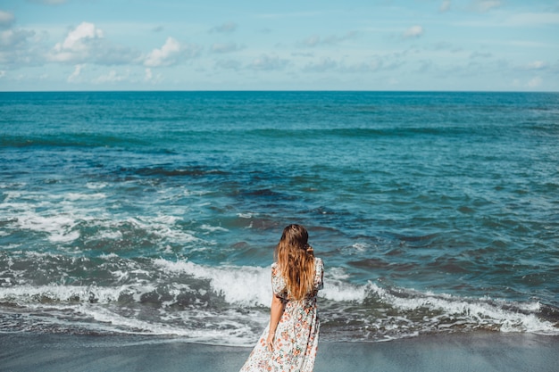 young beautiful girl posing on the beach, ocean, waves, bright sun and tanned skin