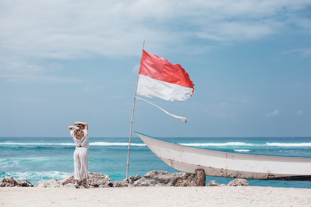 young beautiful girl posing on the beach, ocean, waves, bright sun and tanned skin