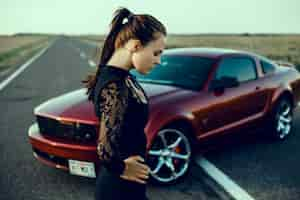 Free photo young beautiful girl posing near the expensive red car, powerful car