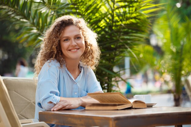 Young beautiful girl, sitting in cafe.