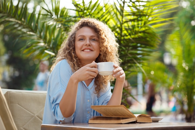 Young beautiful girl sitting in cafe.